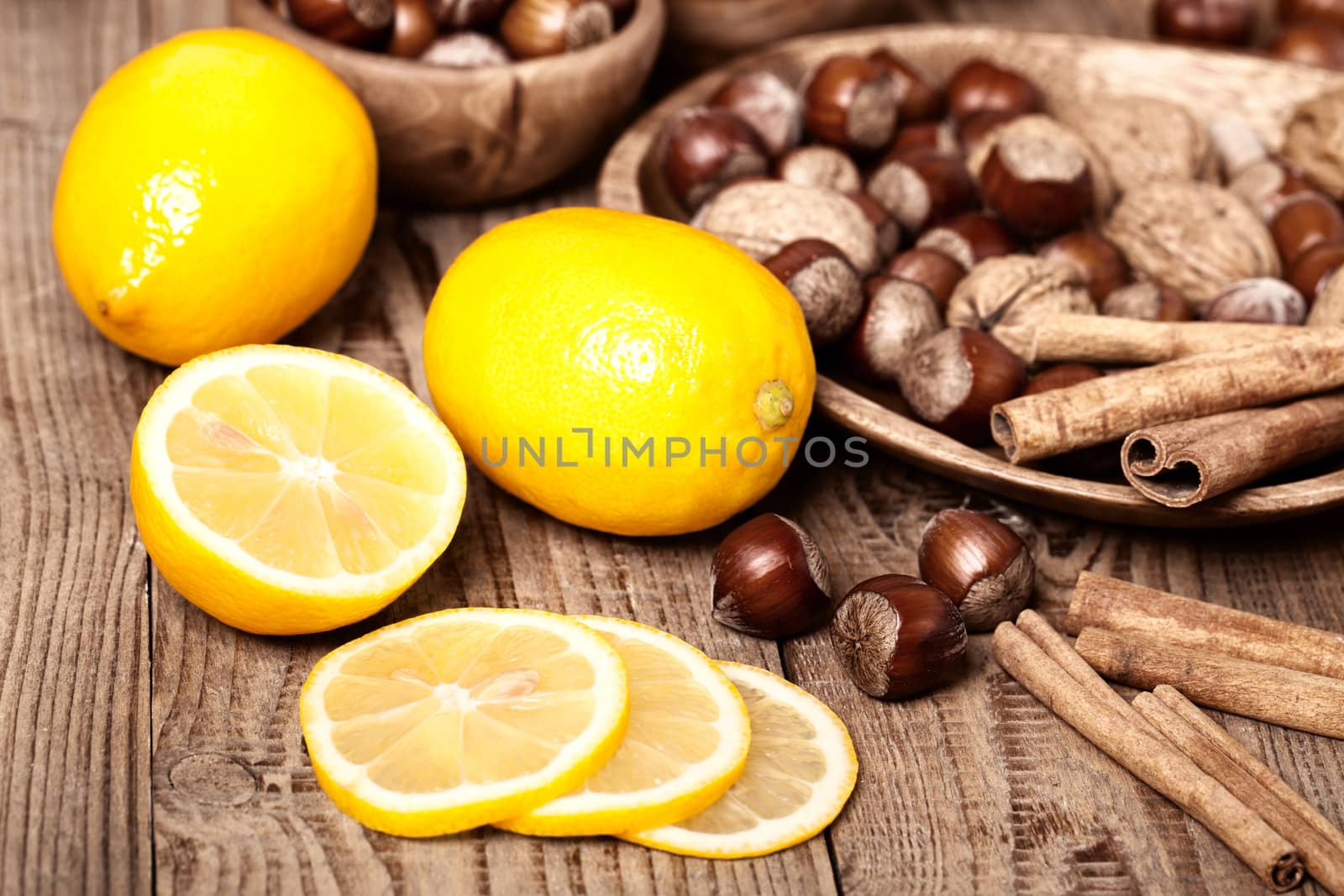 Lemons with hazelnut on wooden background by motorolka