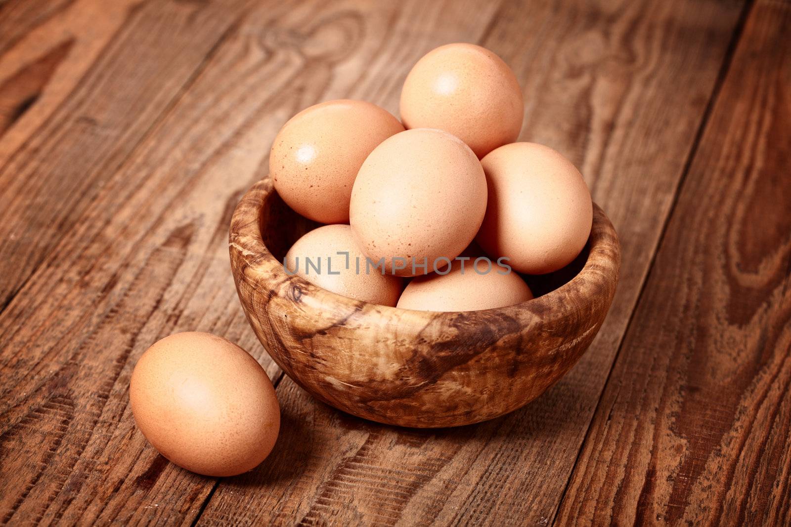 fresh brown eggs on wooden background by motorolka