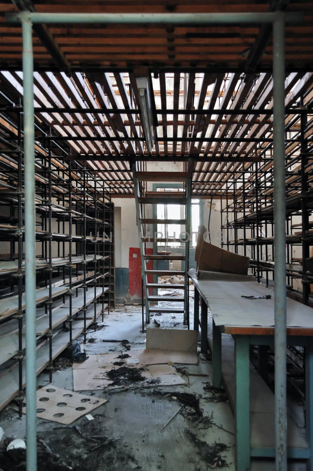 Empty shelves in abandoned vinyl records pressing factory storage room.