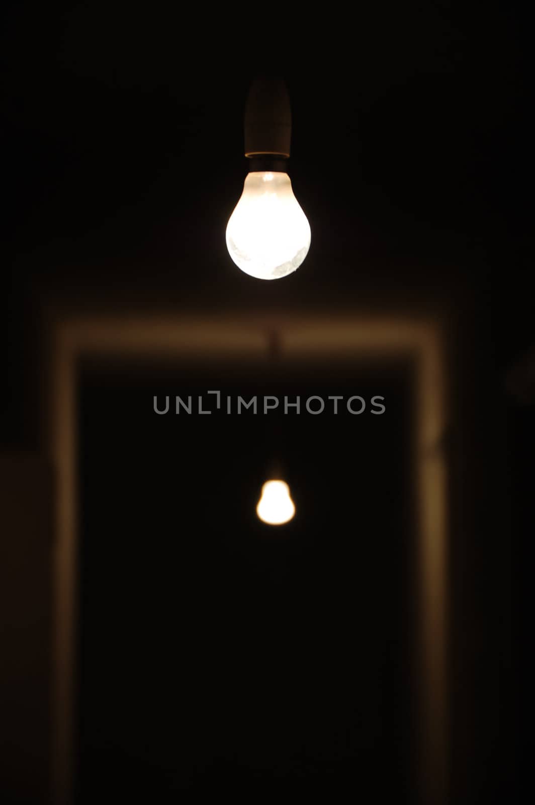 Bare light bulbs in dark underground hallway.