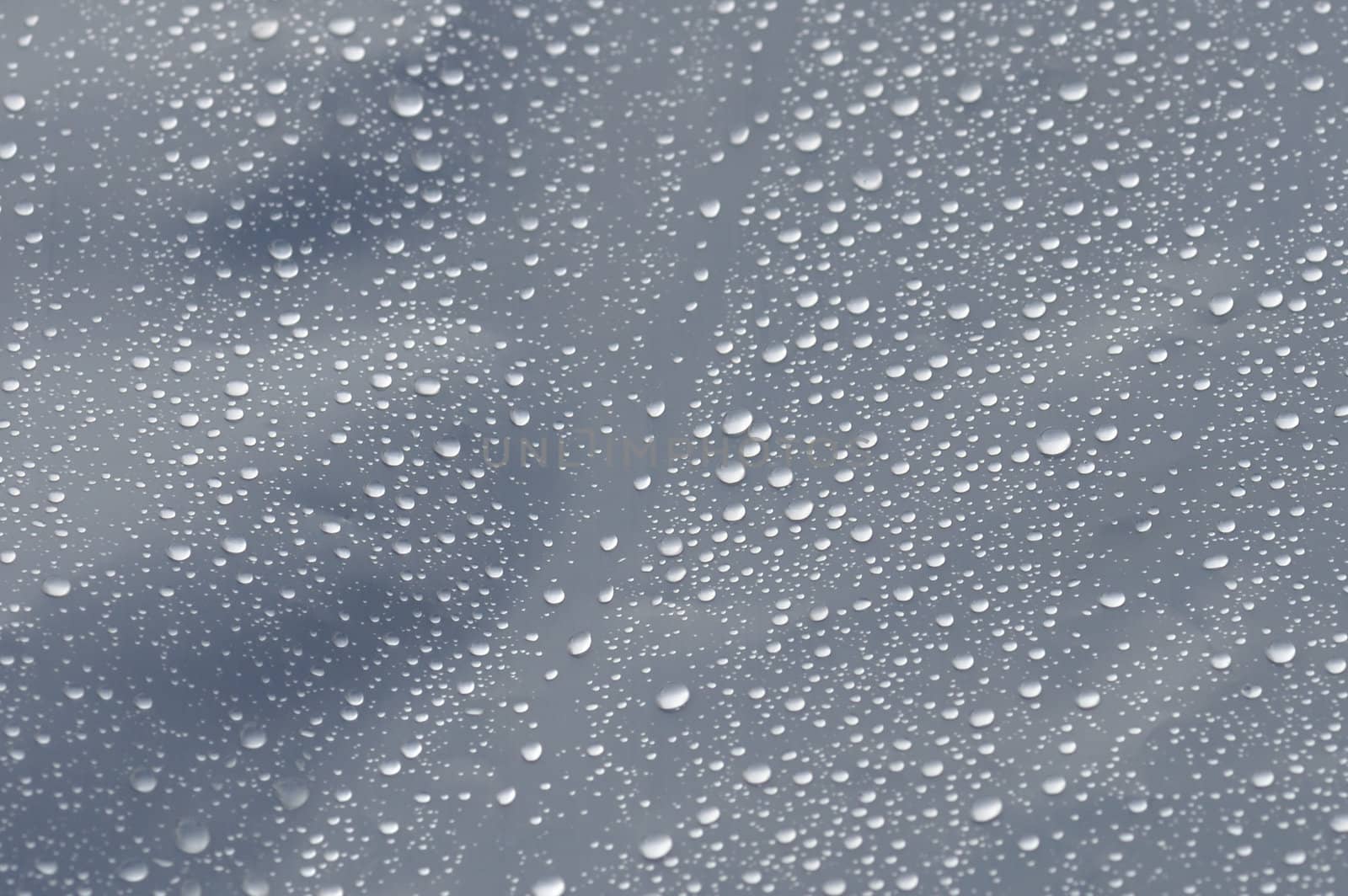 Raindrops on transparent plastic background texture. Selective focus.