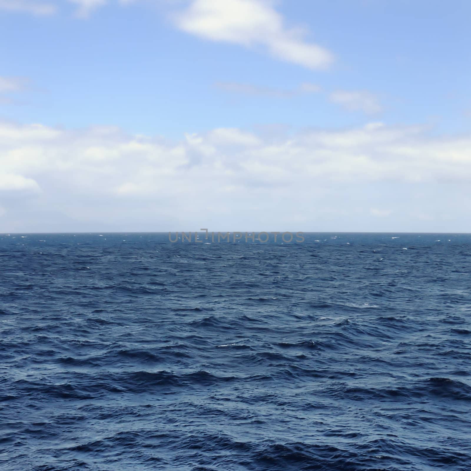 Deep open sea water and blue sky horizon.