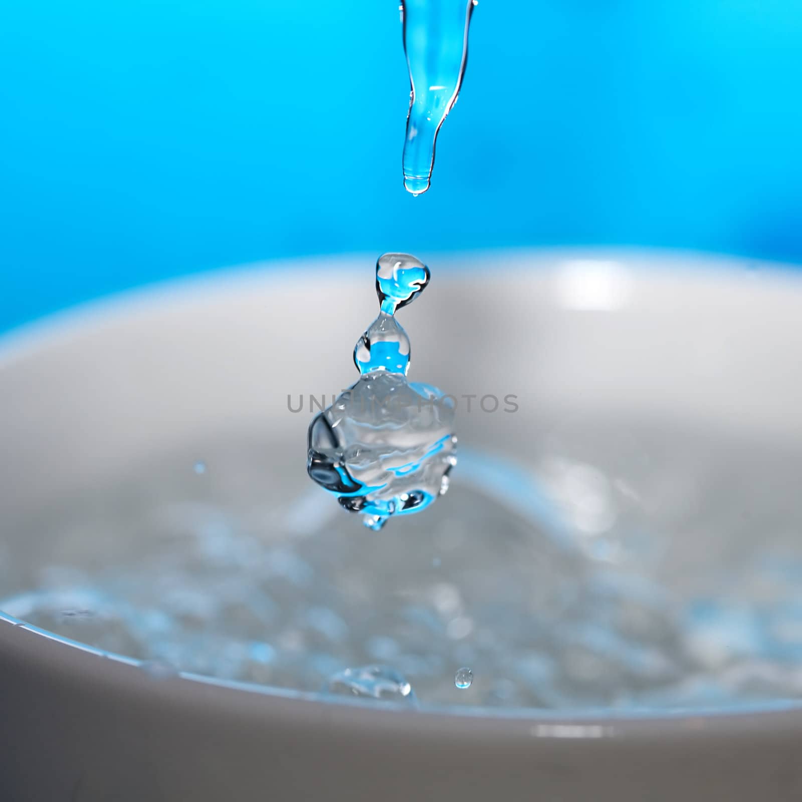water splash in a cup on a blue background by jannyjus
