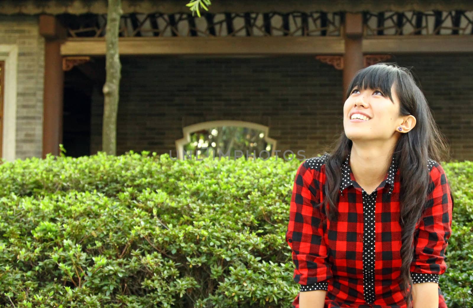 Chinese girl smiling in a garden