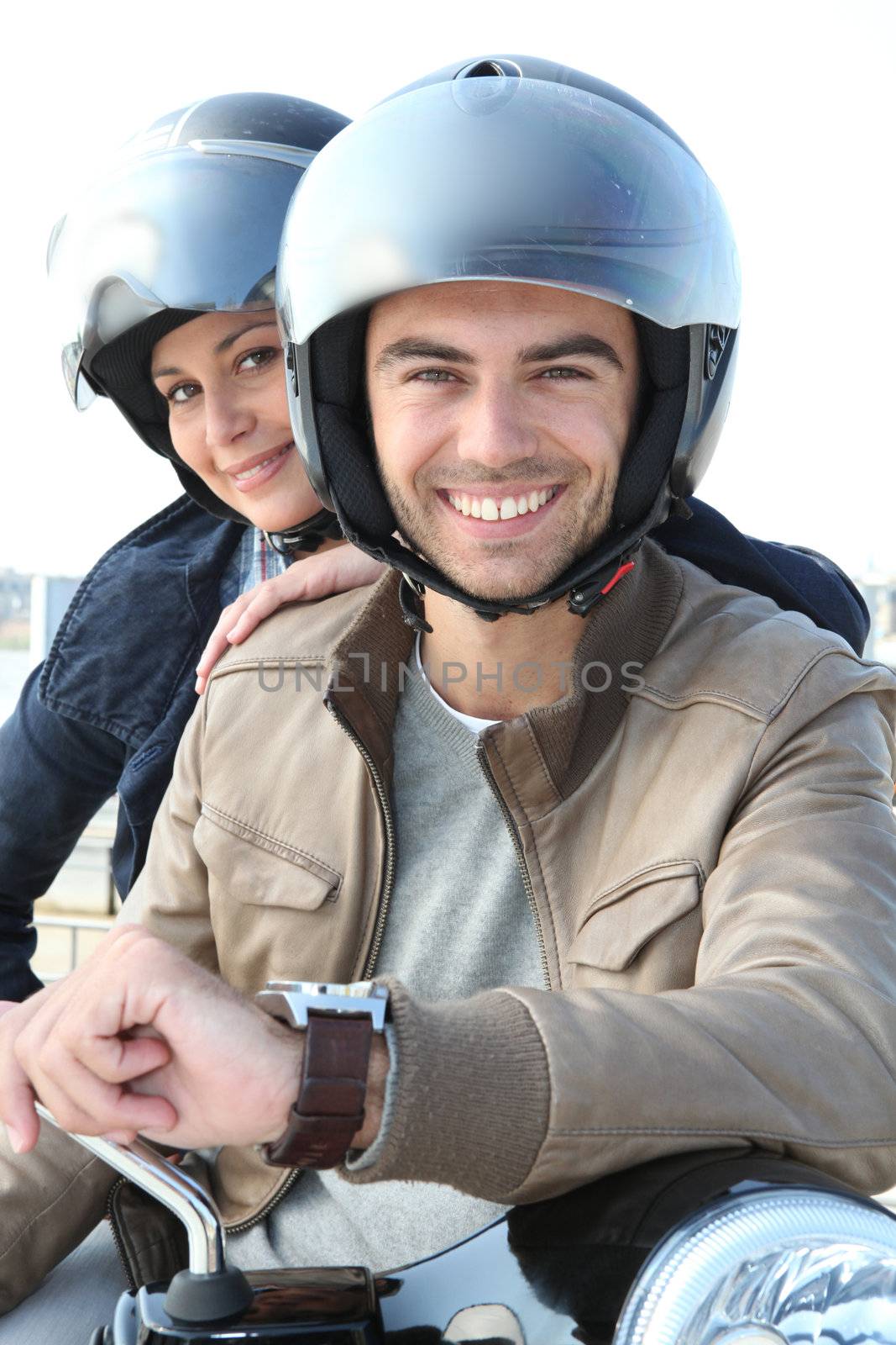 Couple smiling on a motorcycle by phovoir