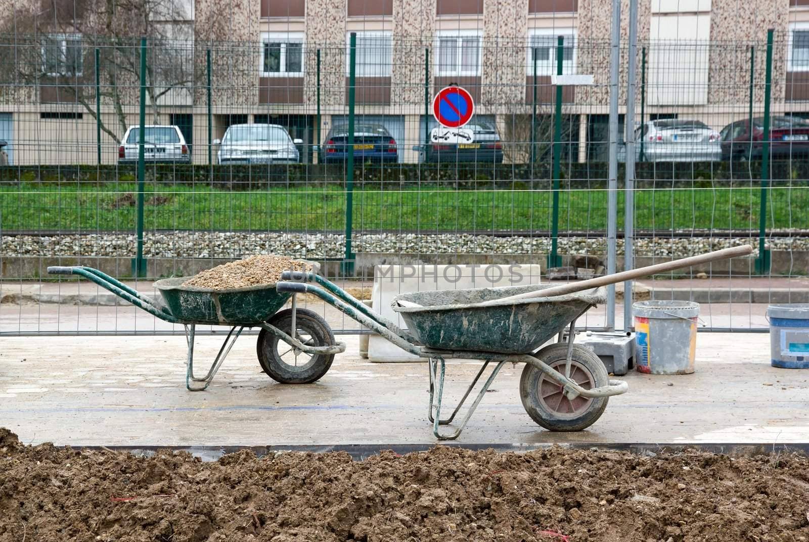 Wheelbarrows in wait of use, construction sites in a city