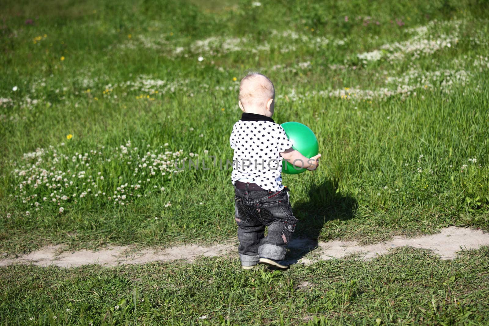  little boy play in green grass with green ball