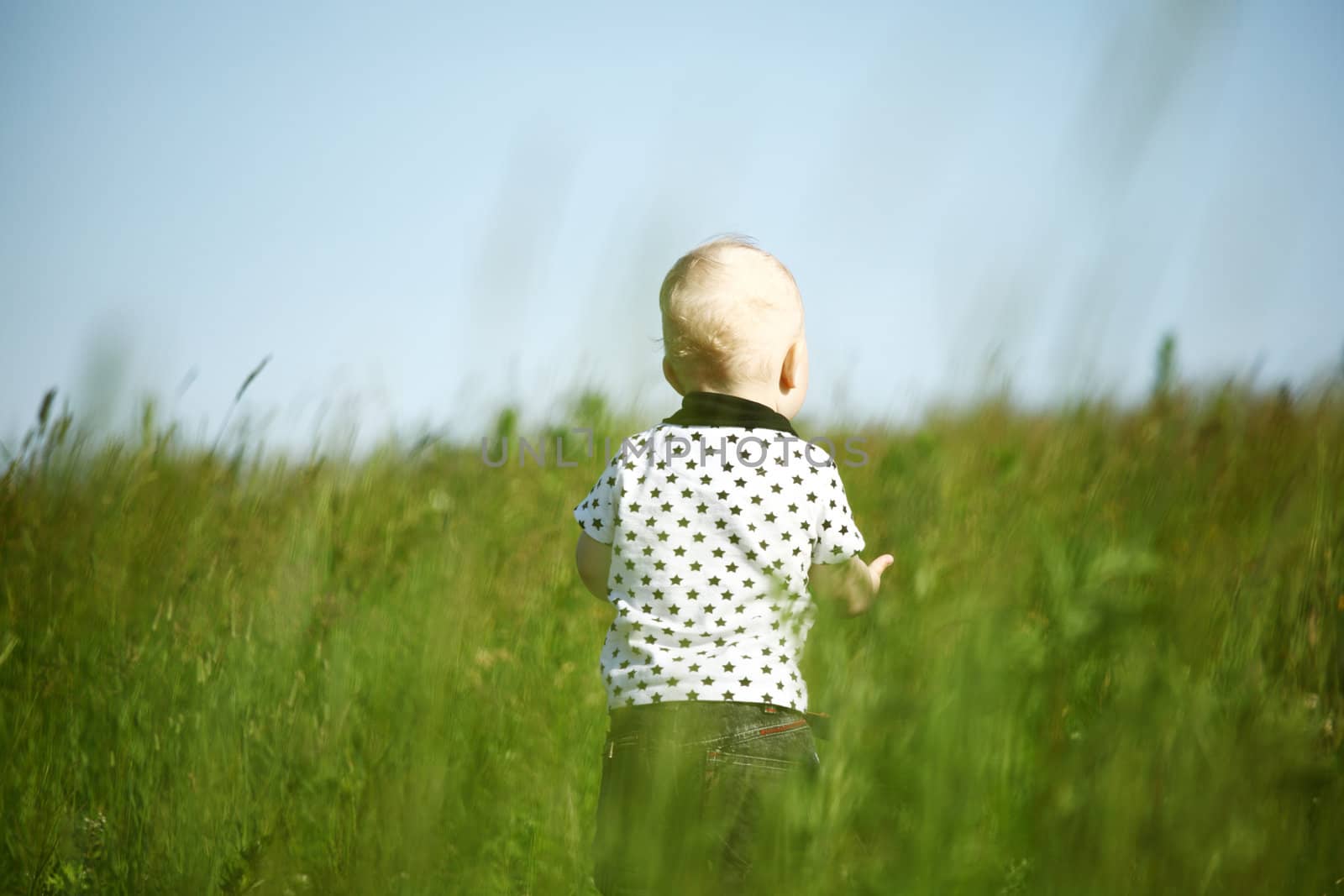  little boy play in green grass with green ball