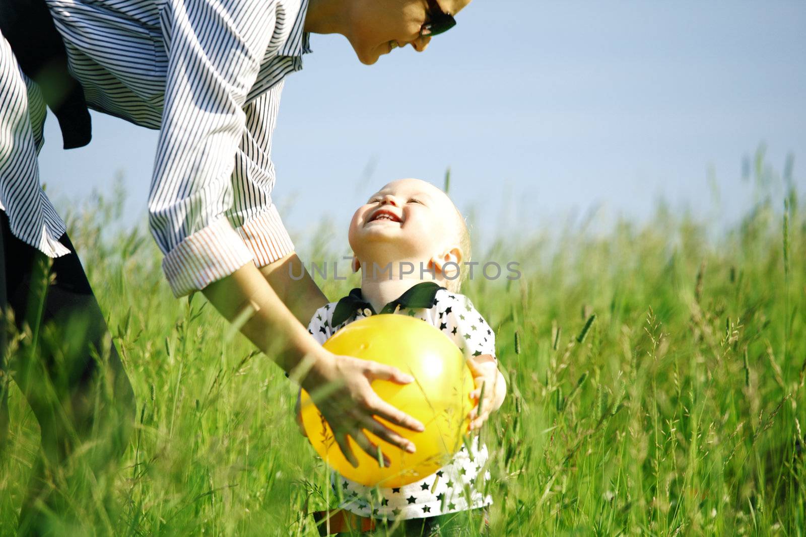  little boy play in green grass with yellow ball