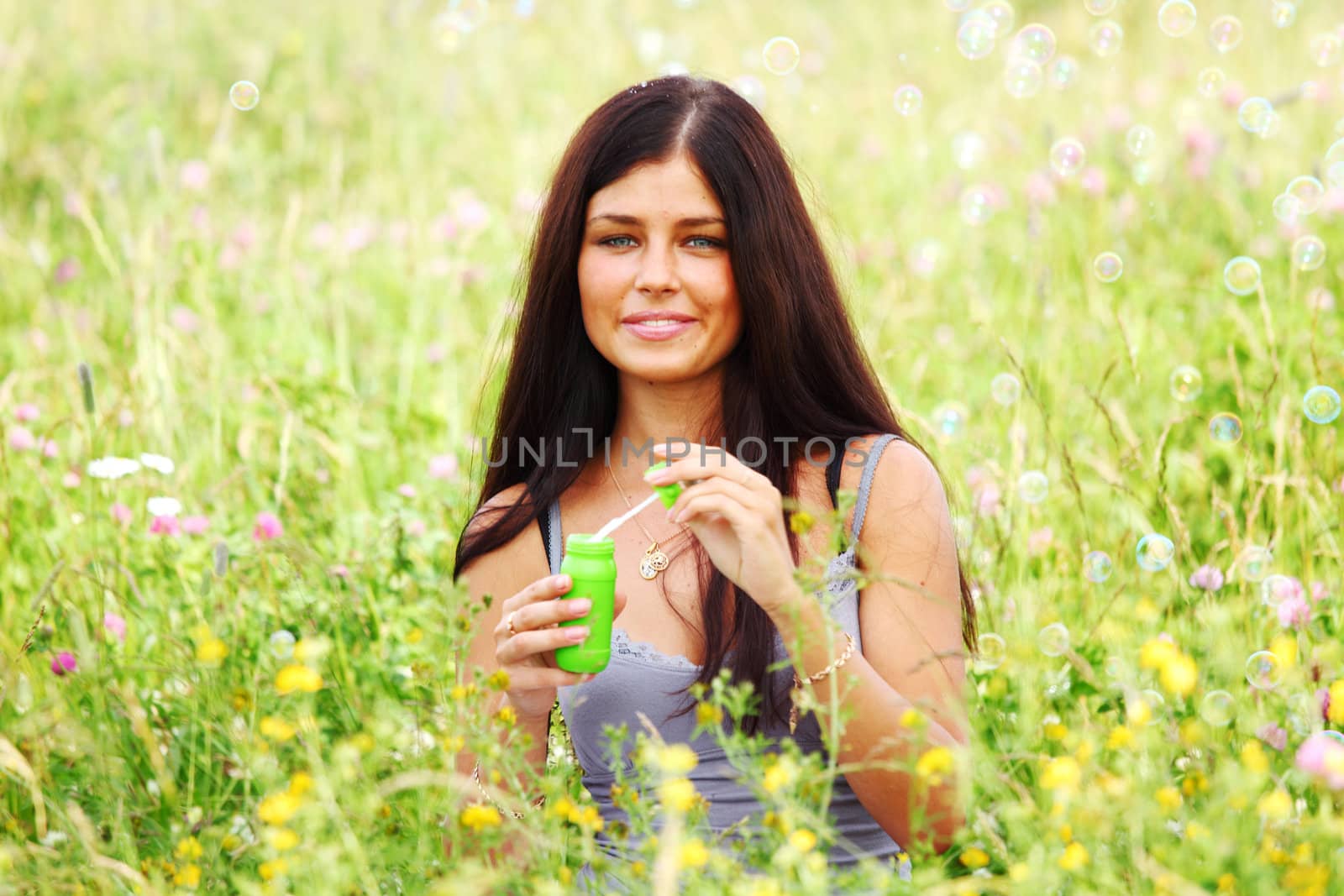  happy woman smile in green grass soap bubbles around