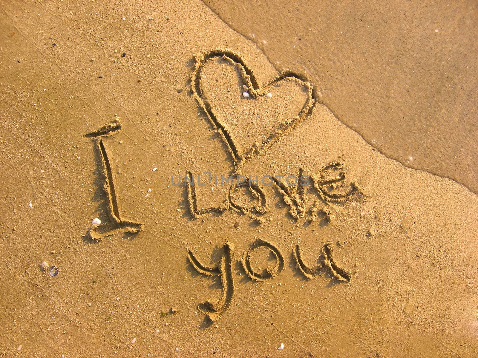 I love you written on the beach and one wavelet erasing it