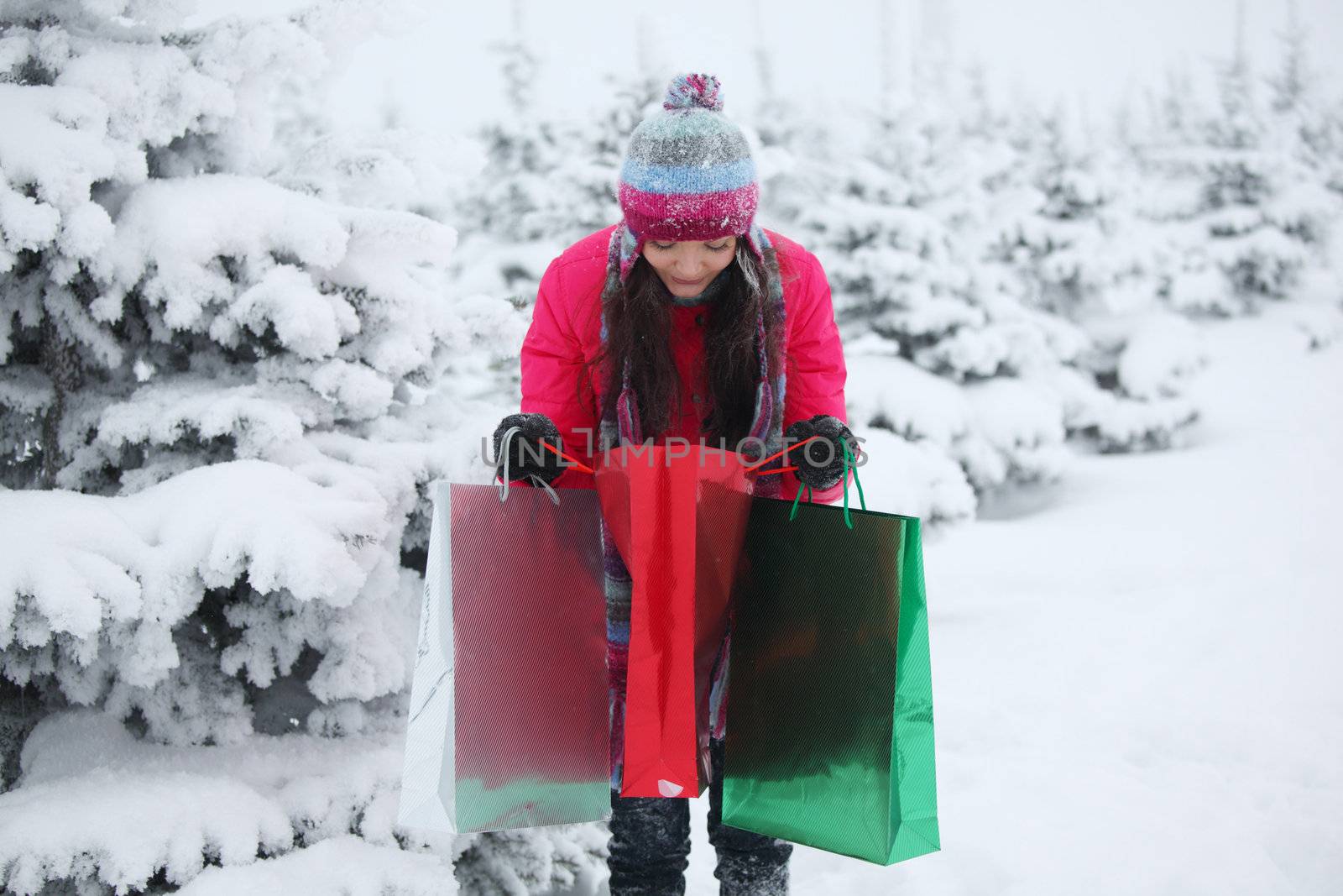 winter girl with gift bags on snow background