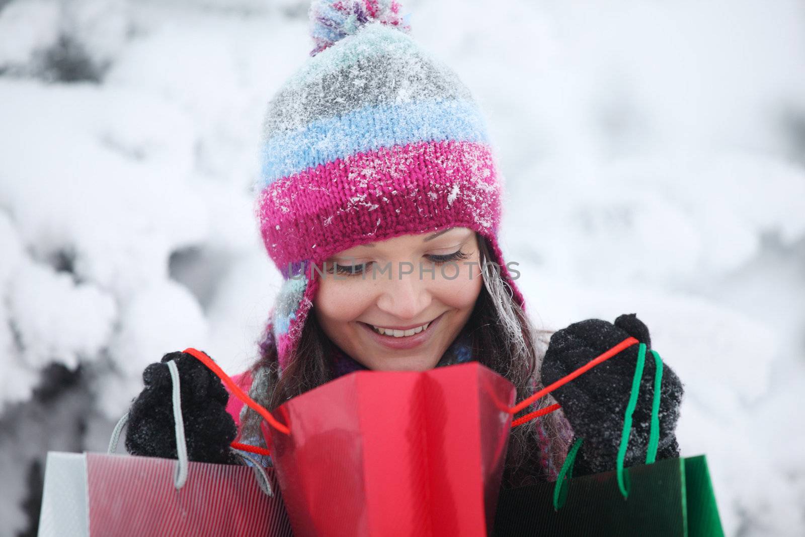 winter girl with gift bags on snow background