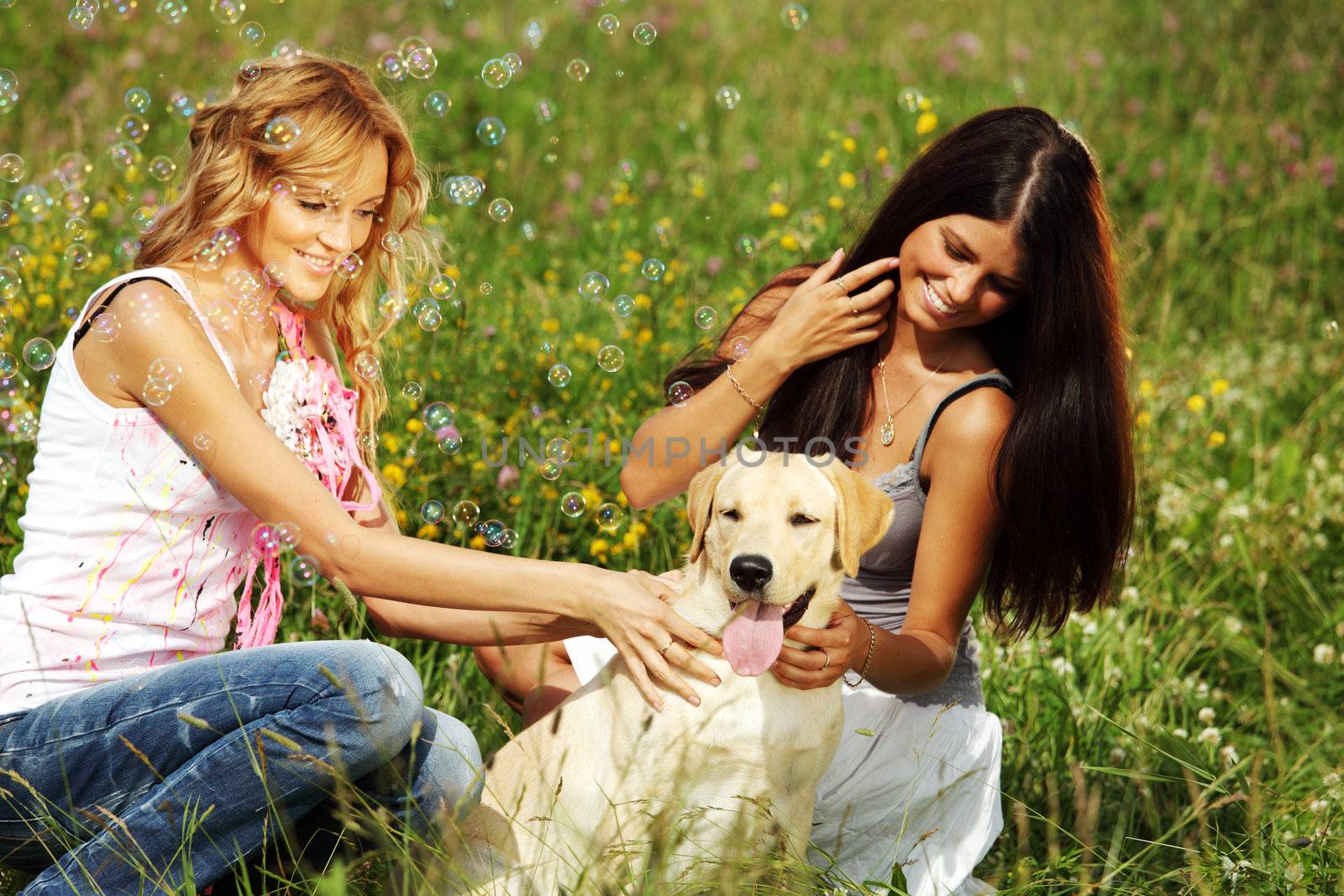 girlfriends and dog in green grass field