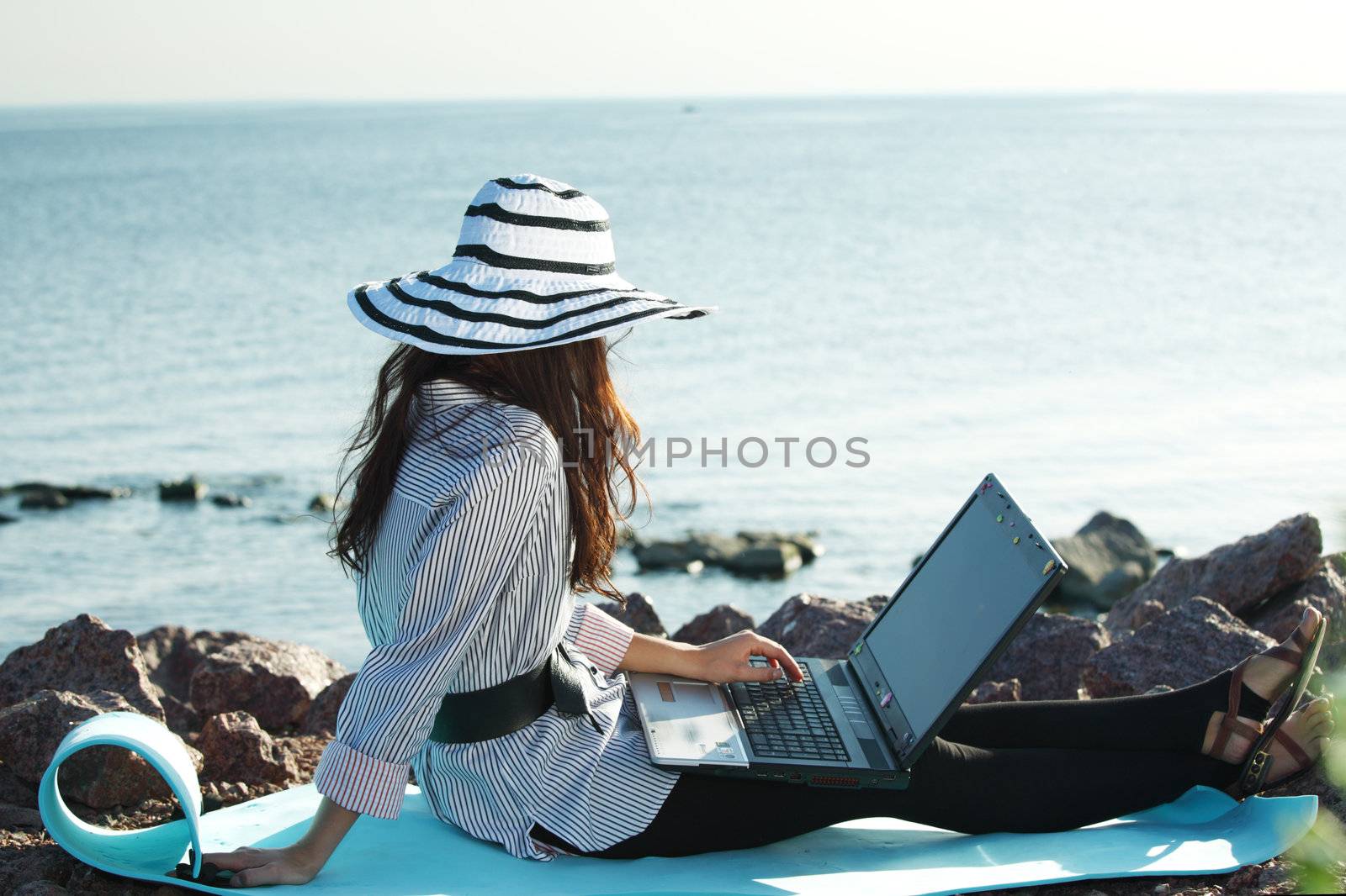 woman with laptop sea background