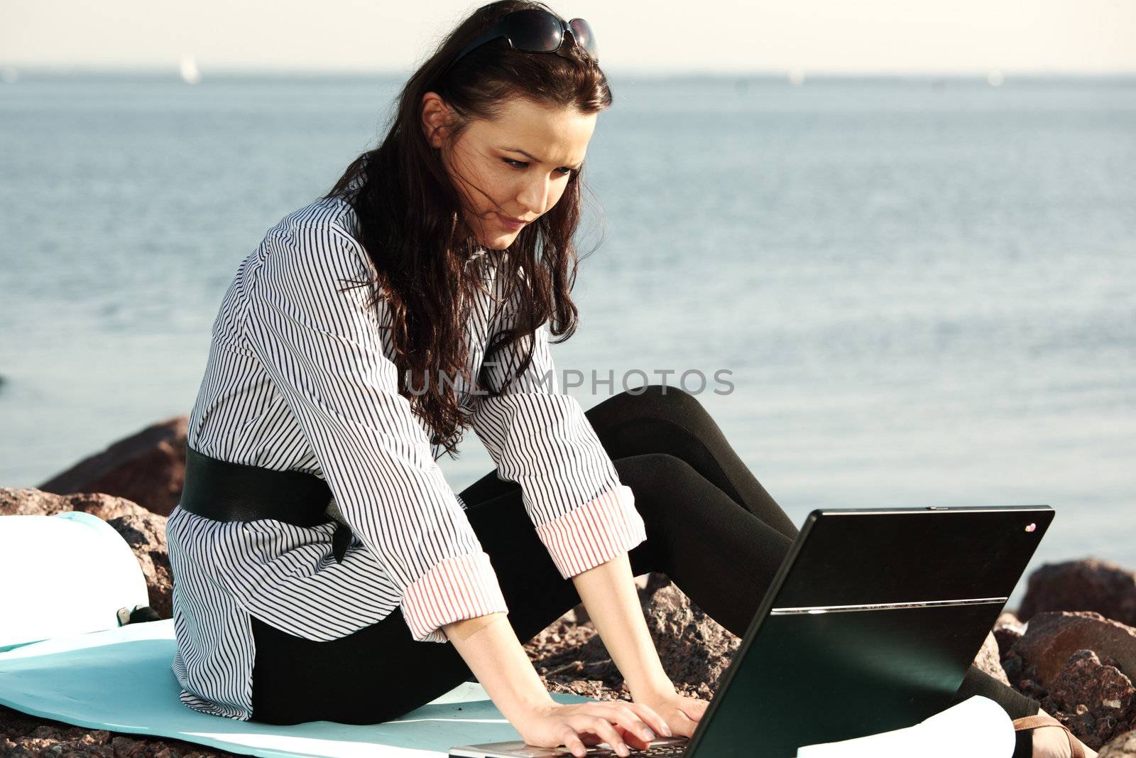 woman with laptop sea background