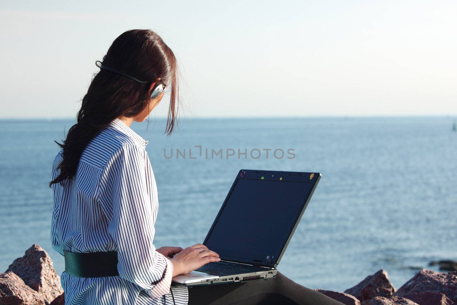 woman with laptop sea background