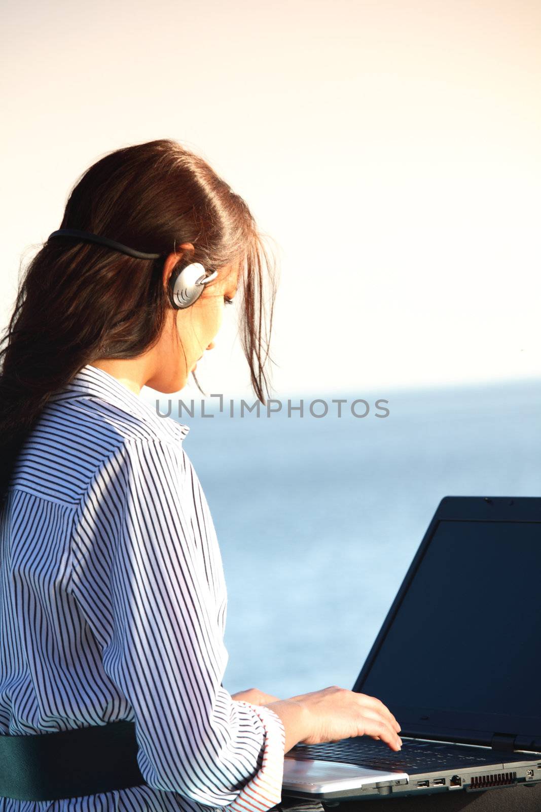 woman with laptop sea background