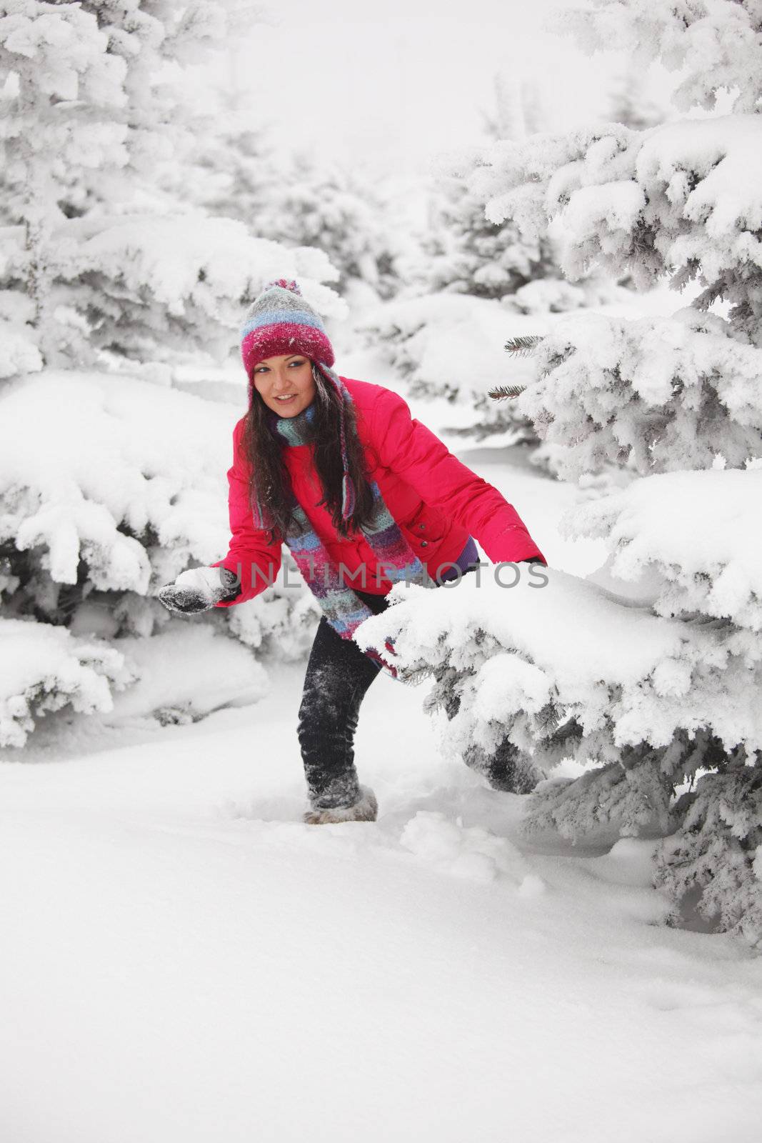 winter woman play snowballs on snow background