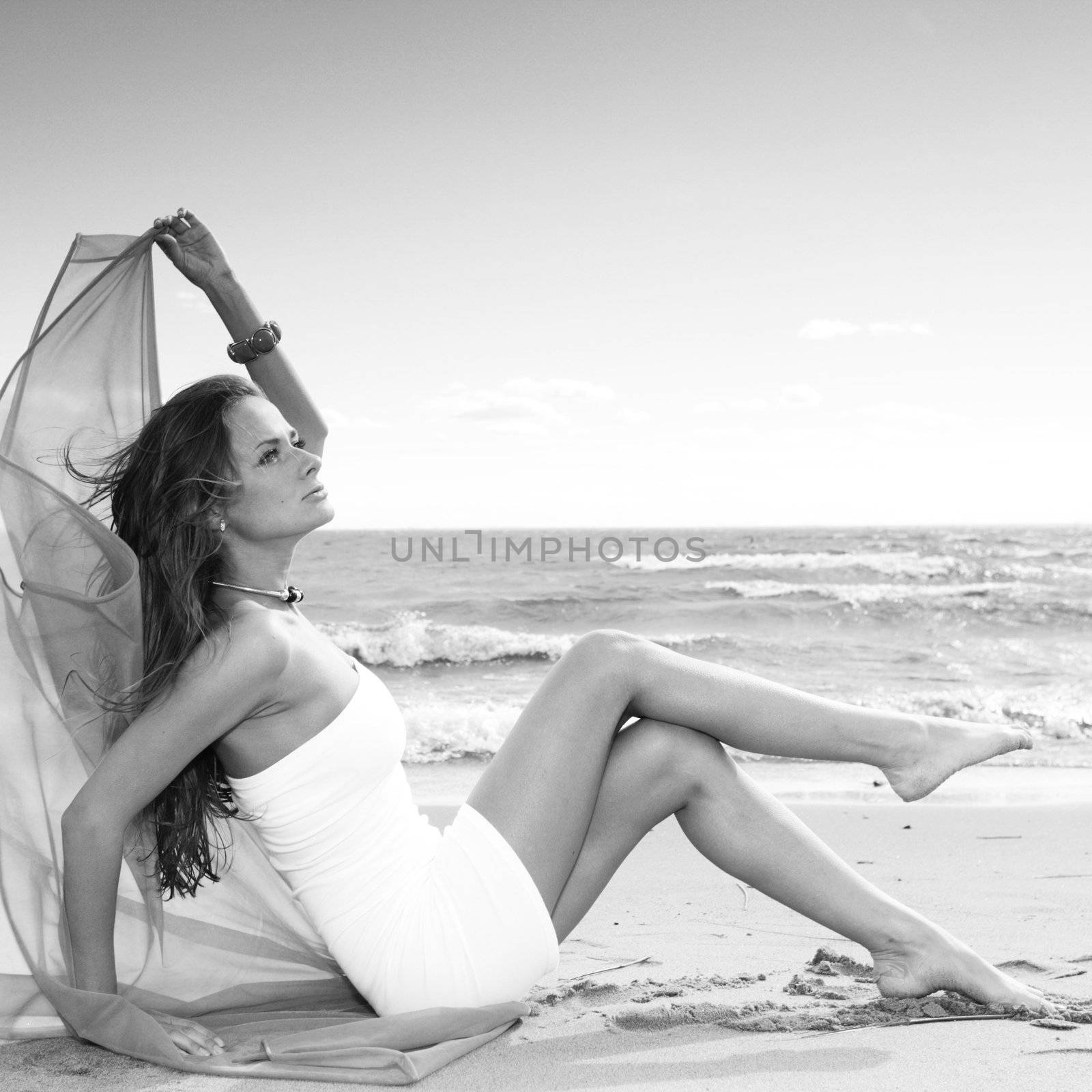 woman laying on sand sea on background