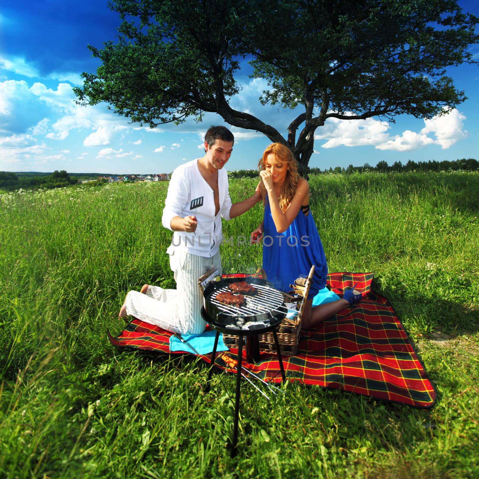 man and woman on picnic in green grass