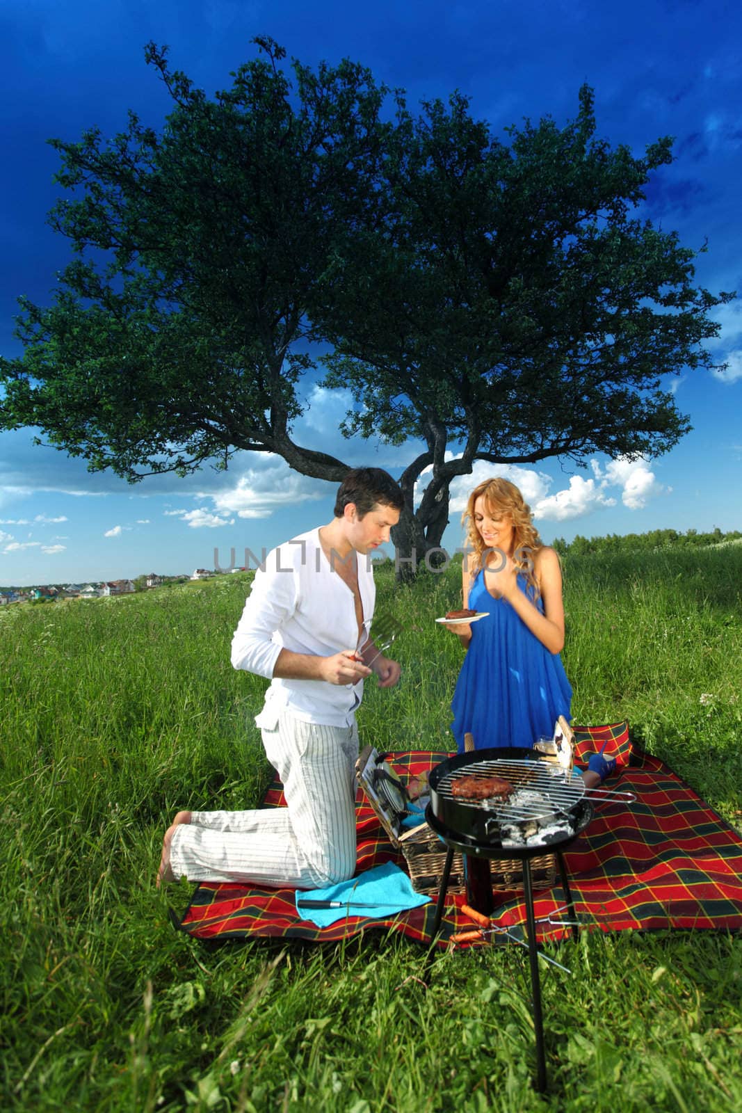 man and woman on picnic in green grass