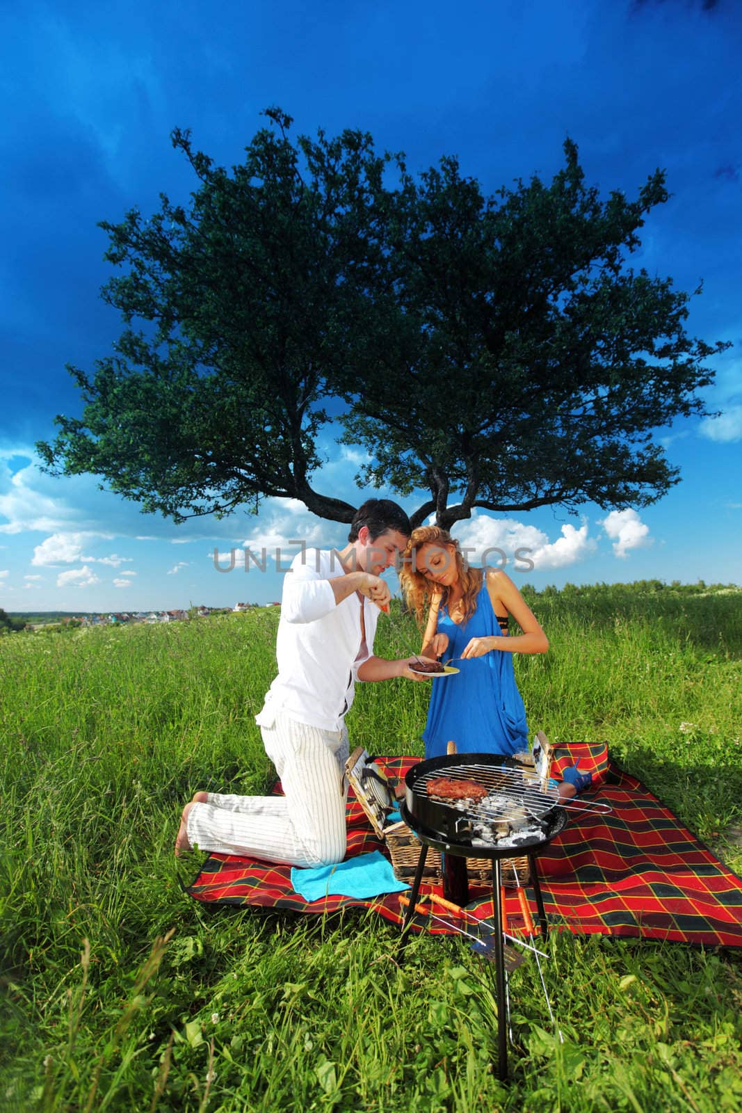 man and woman on picnic in green grass