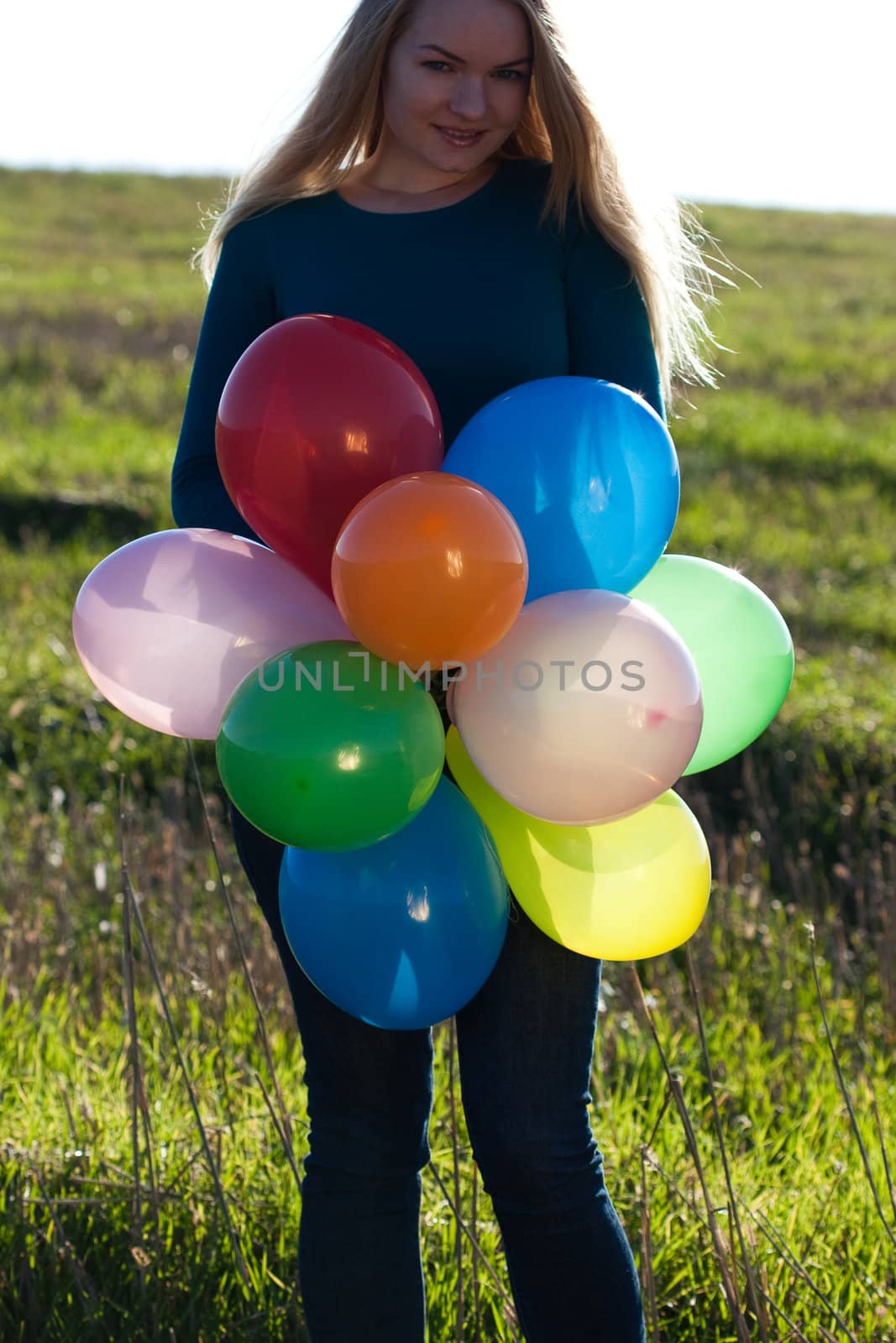 young beautiful woman with balloons into the field against the s by jannyjus