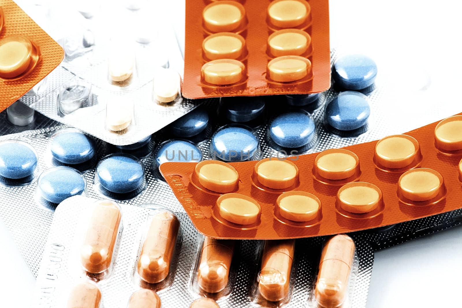 Pills of many shapes and colors grouped together.