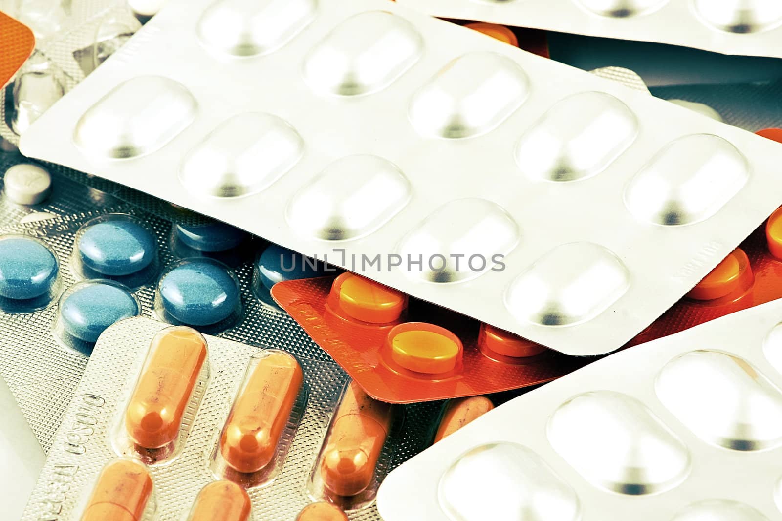 Pills of many shapes and colors grouped together.