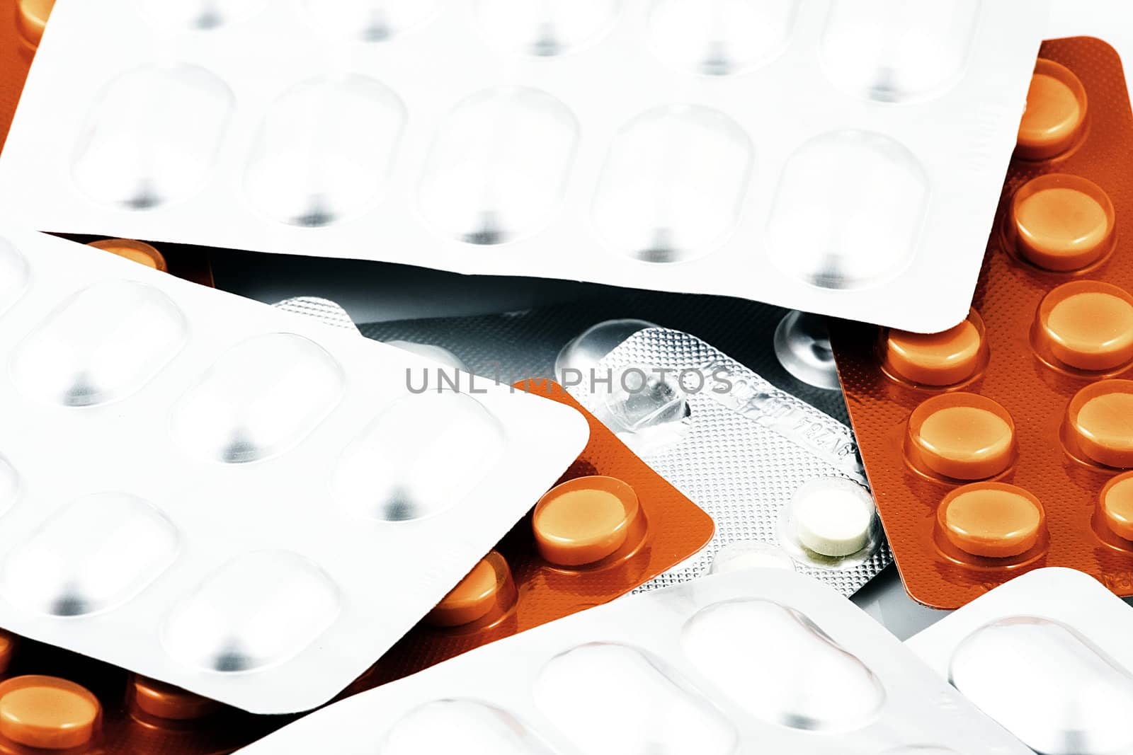 Pills of many shapes and colors grouped together.