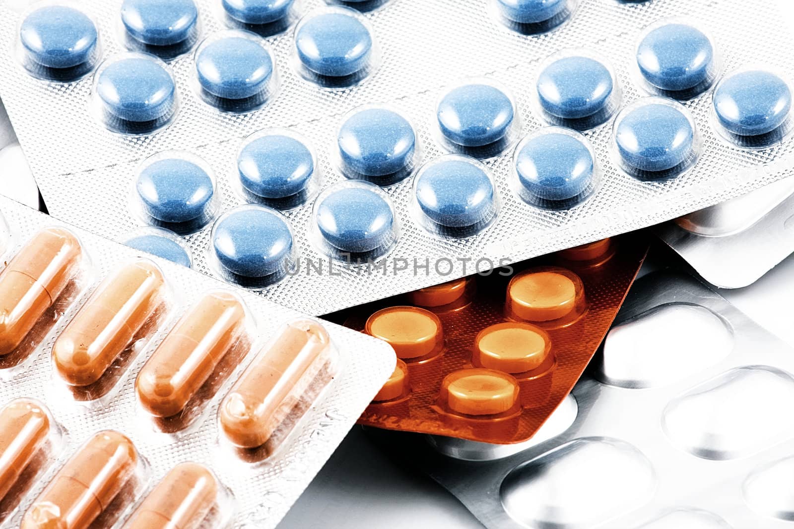 Pills of many shapes and colors grouped together.