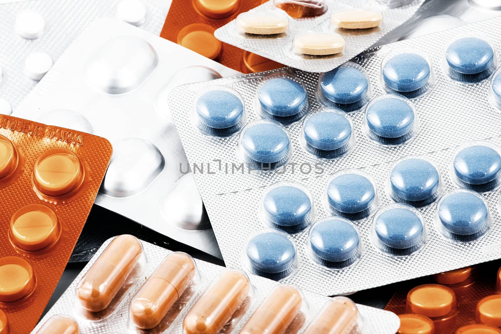 Pills of many shapes and colors grouped together.