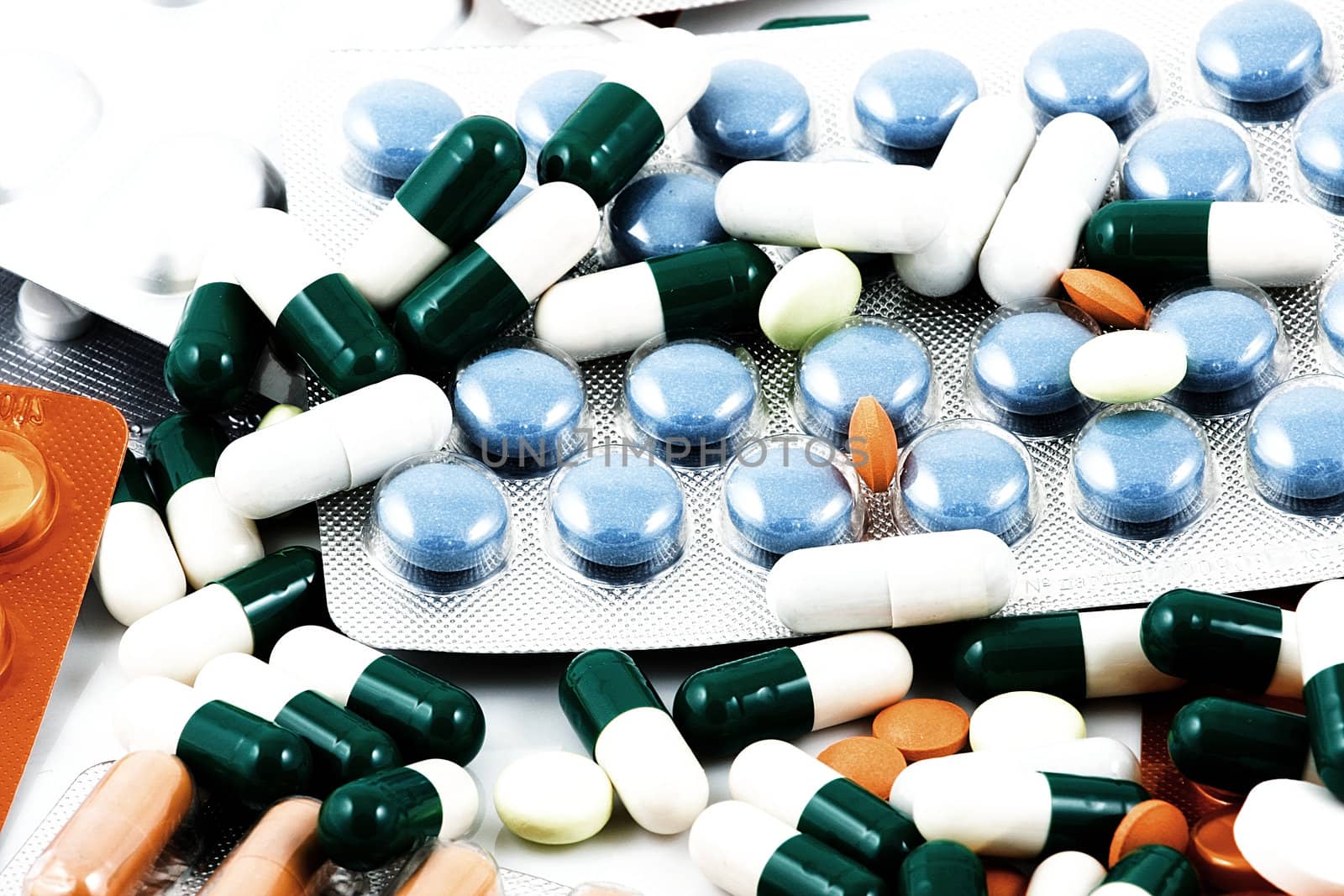Pills of many shapes and colors grouped together.