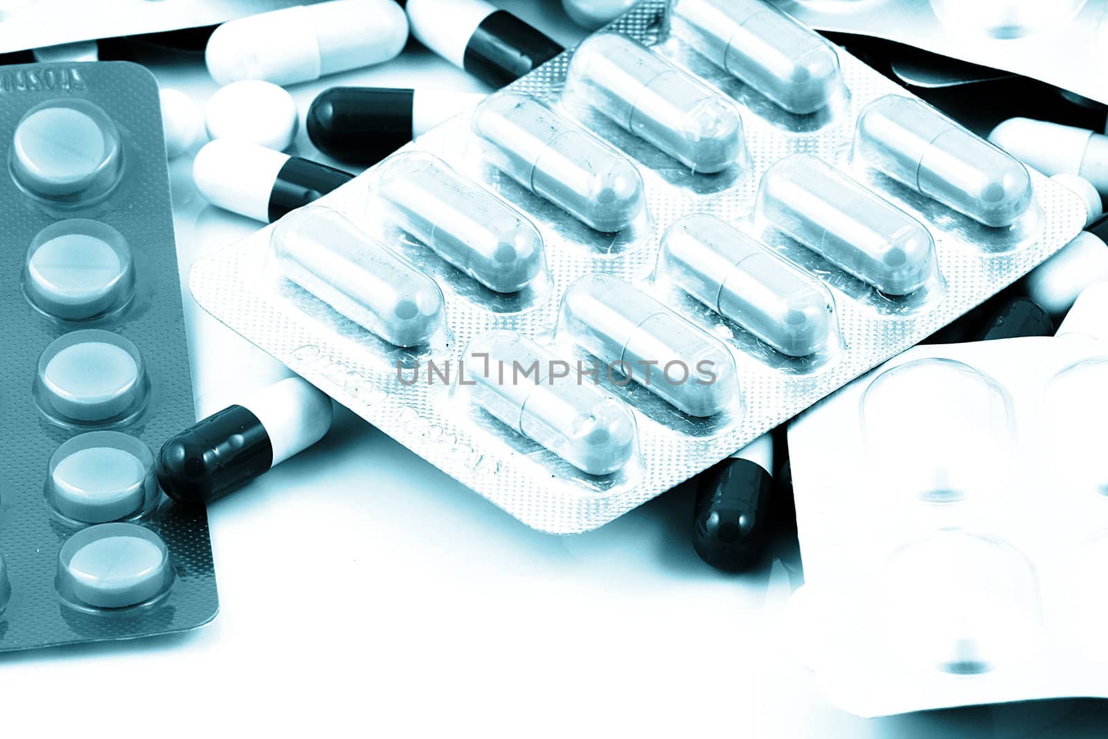 Pills of many shapes and colors grouped together.