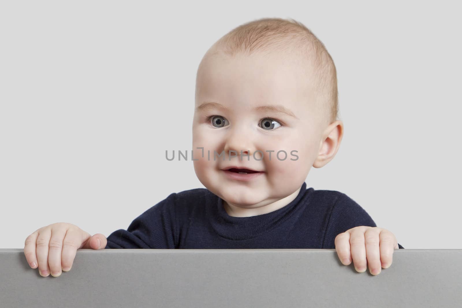 young child holding sign. isolate on grey background