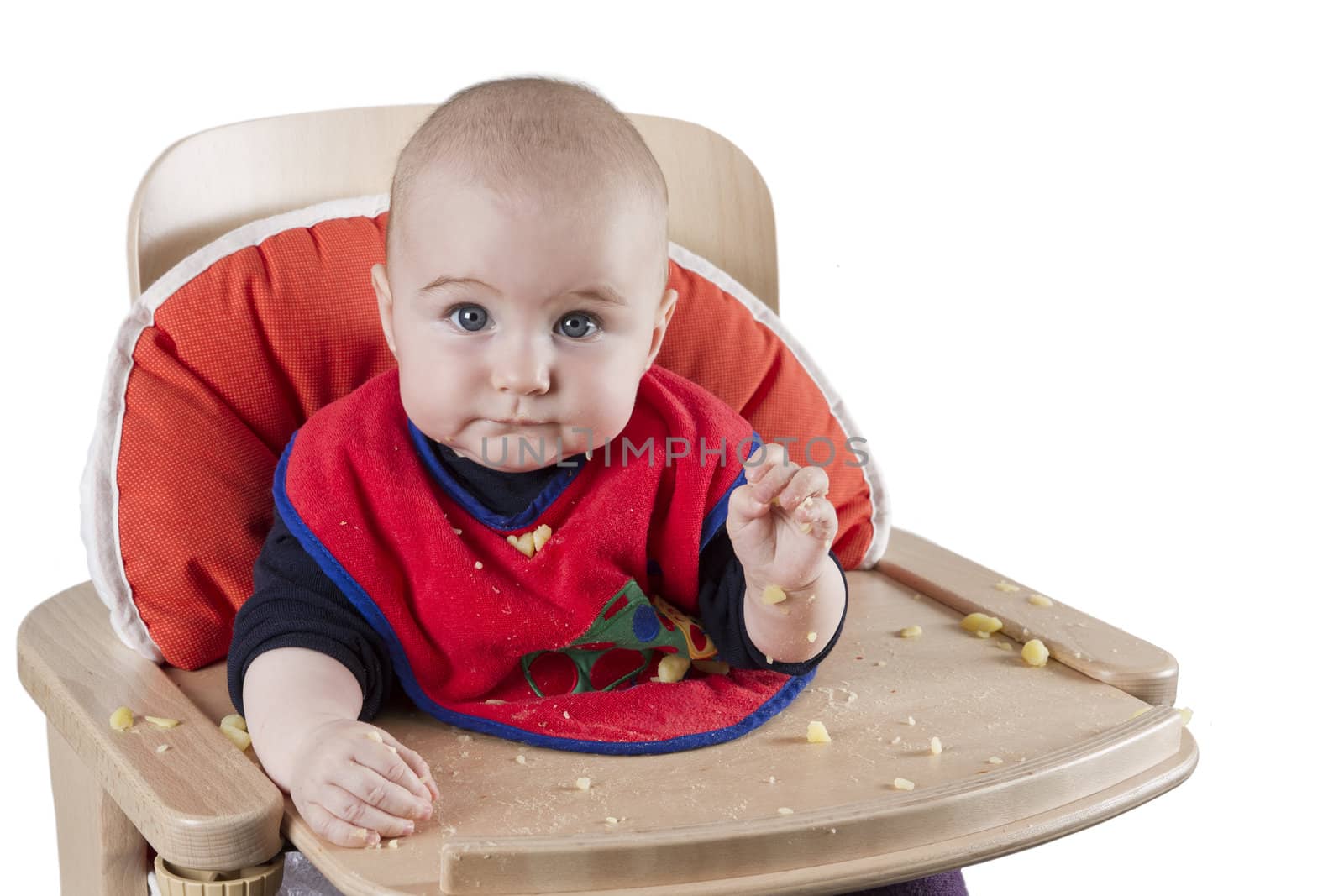 toddler eating potatoes in highchair