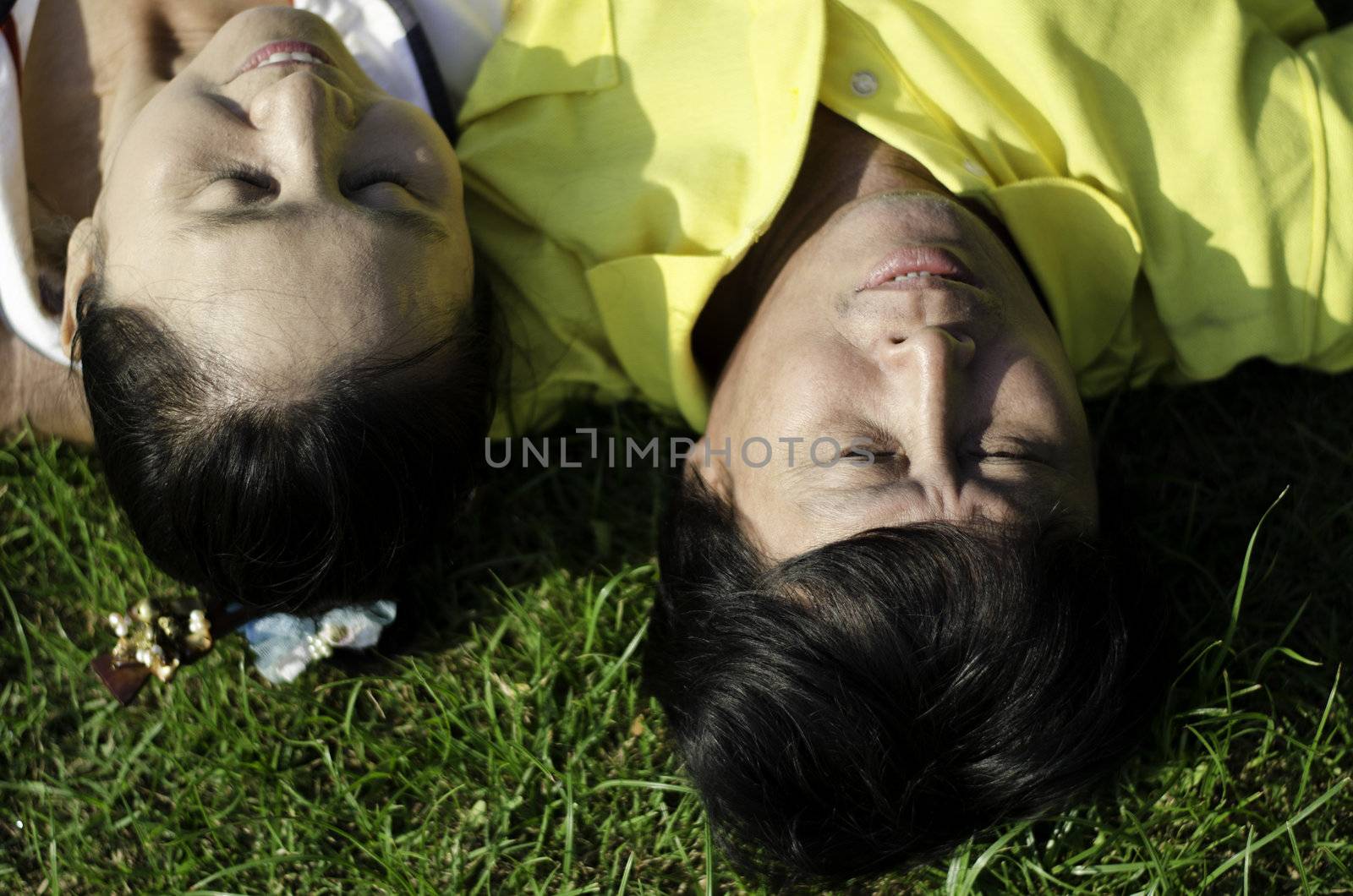 Seniors couple lying on grass outdoor