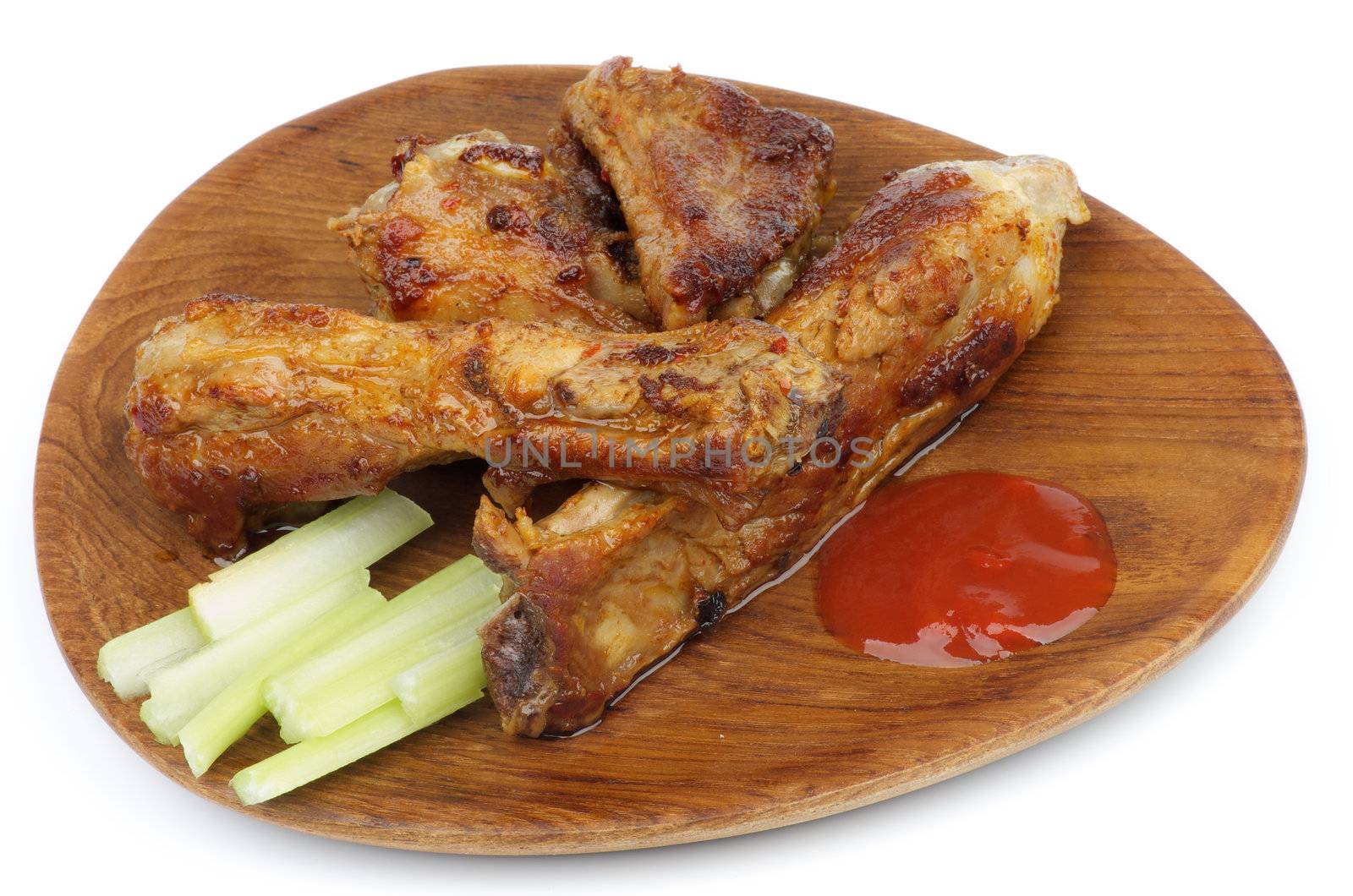 Wooden Dinner Plate with Barbecue Pork Ribs, Celery and Ketchup closeup on white background