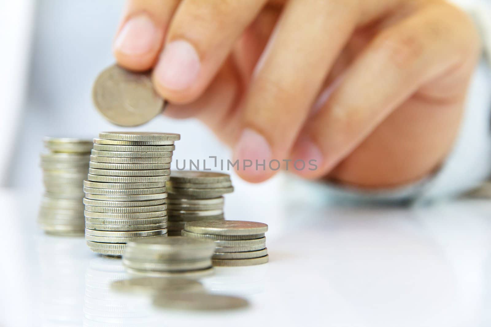 Hand put coin to stack, investment concept