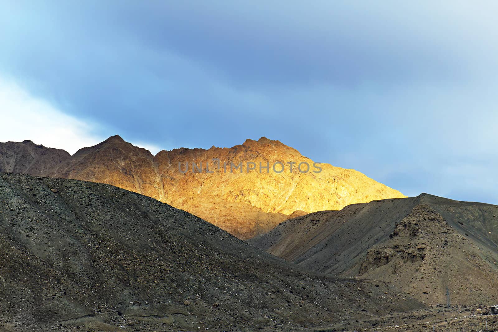 top of the mountain lit by the setting sun in the background