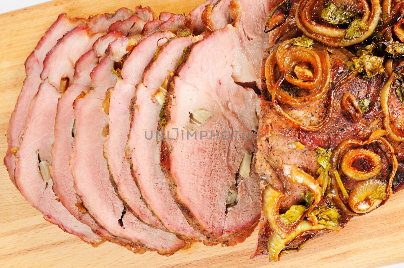 Roast pork on a wooden board. Isolated on white.