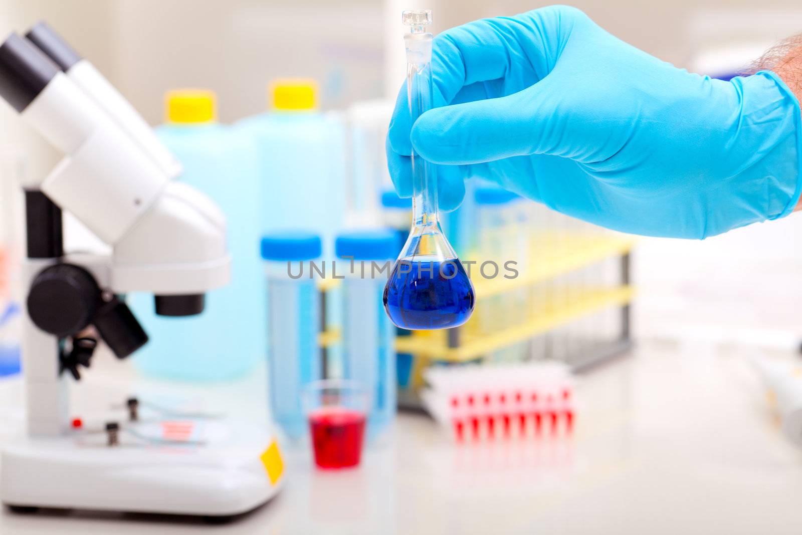 flask with blue liquid in the hand. Science lab research