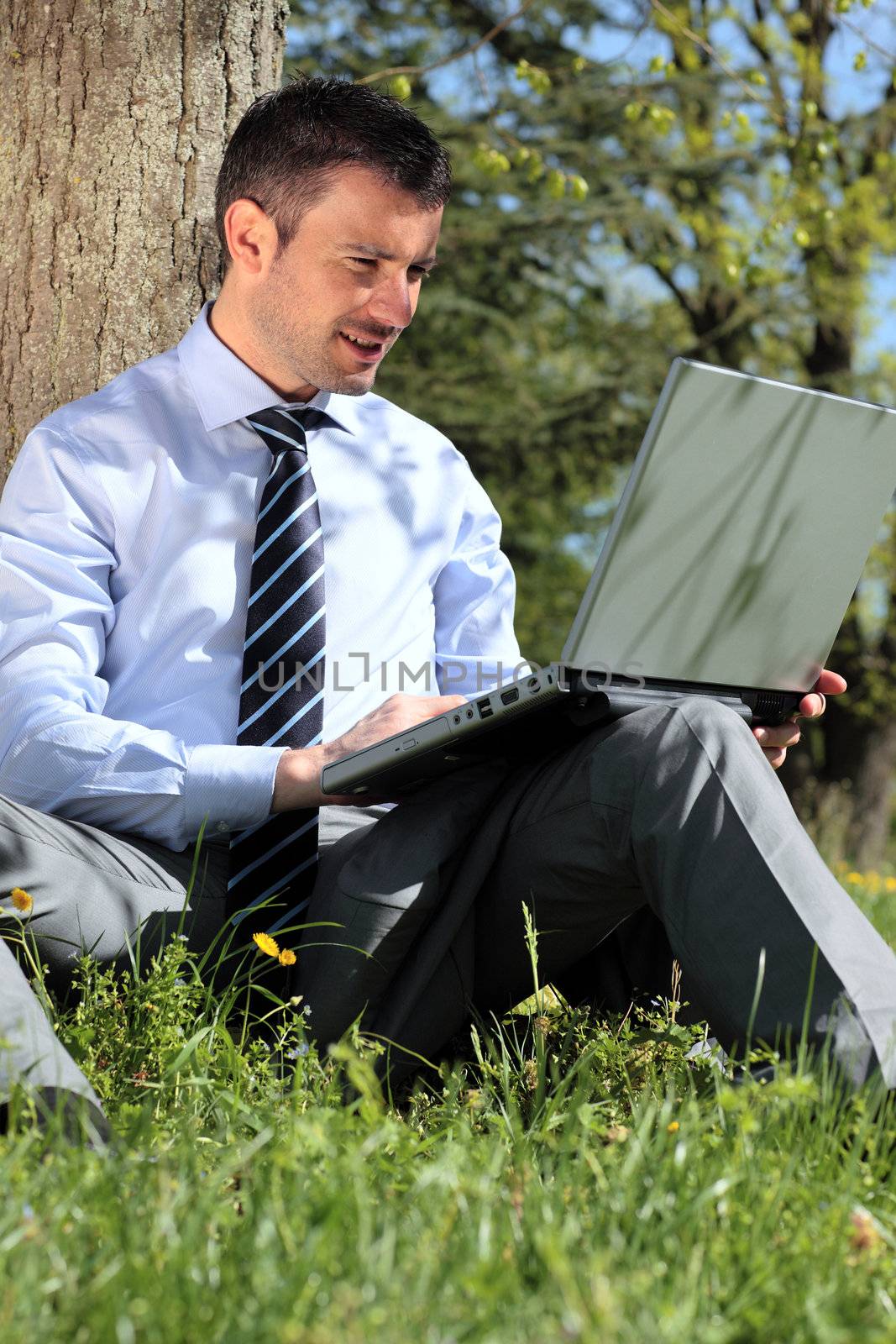 young businessman working with laptop in a park