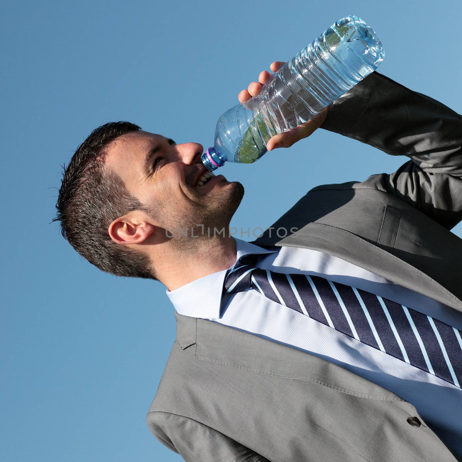 handsome businessman drinking water outdoor