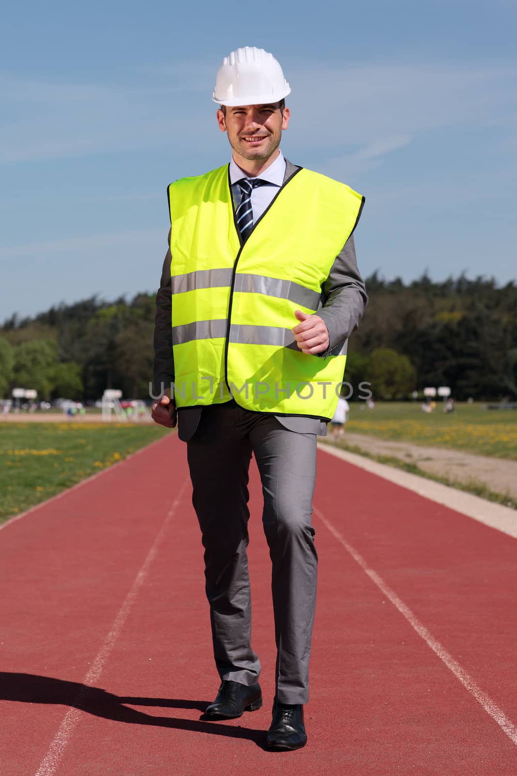 businessman with hard hat and yellow vest on track