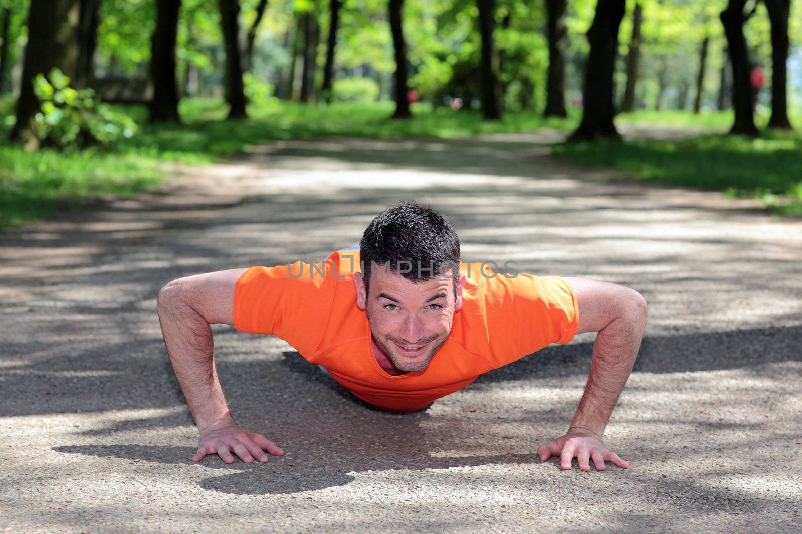 handsome man doing exercises in a park