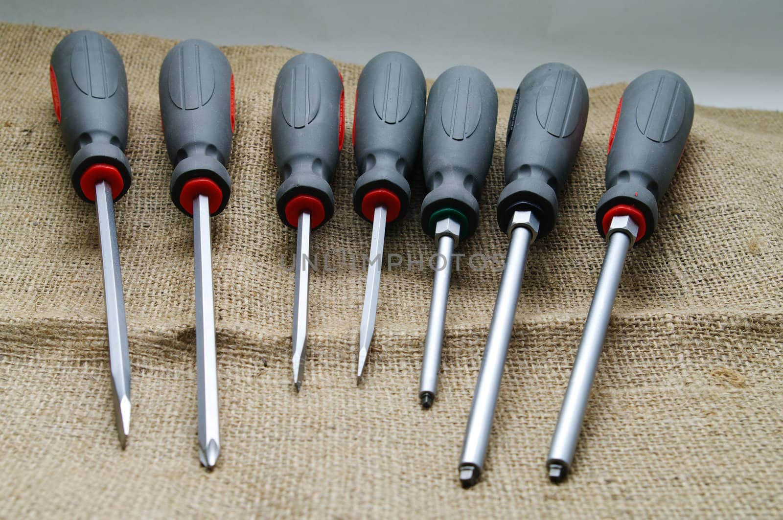 A screwdriver set on a burlap background