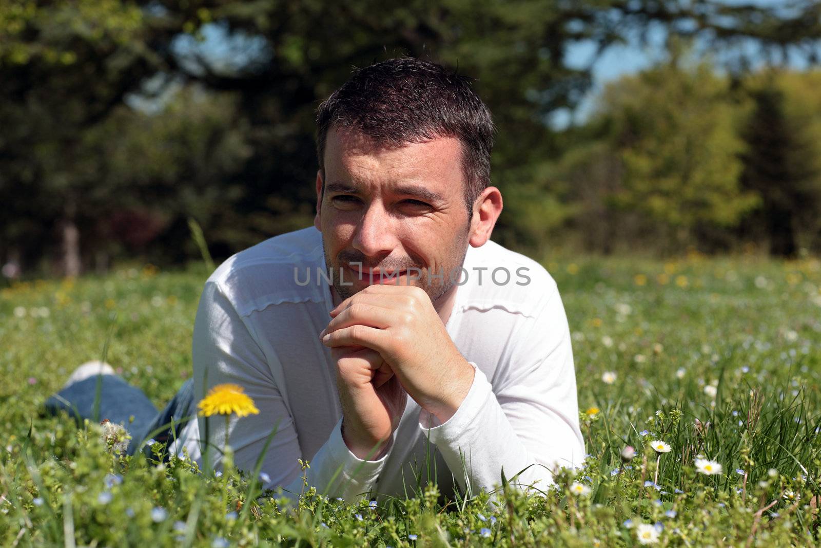 man lying on the grass in a park in spring