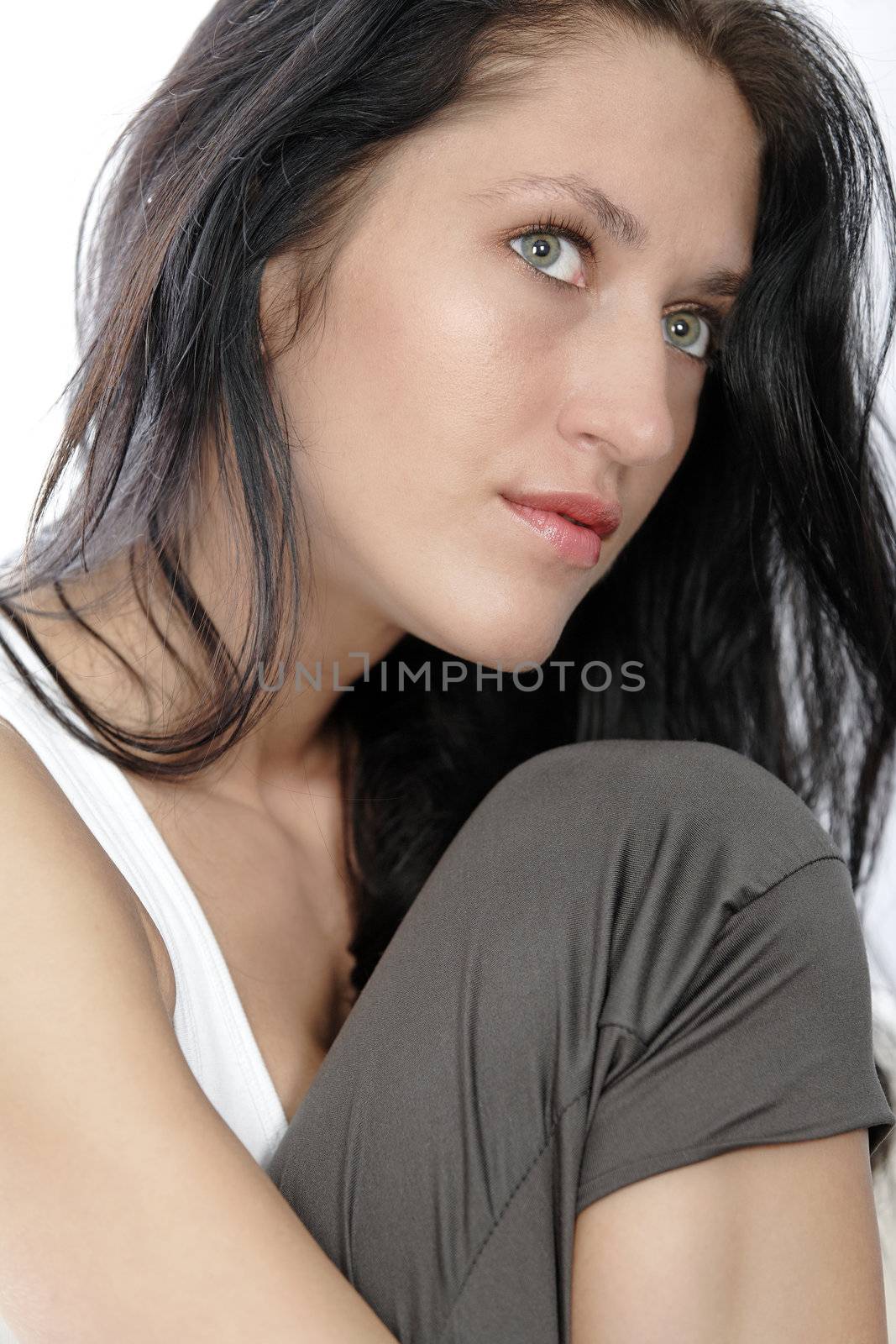 Portrait of a beautiful young woman holding her knee while sat down.